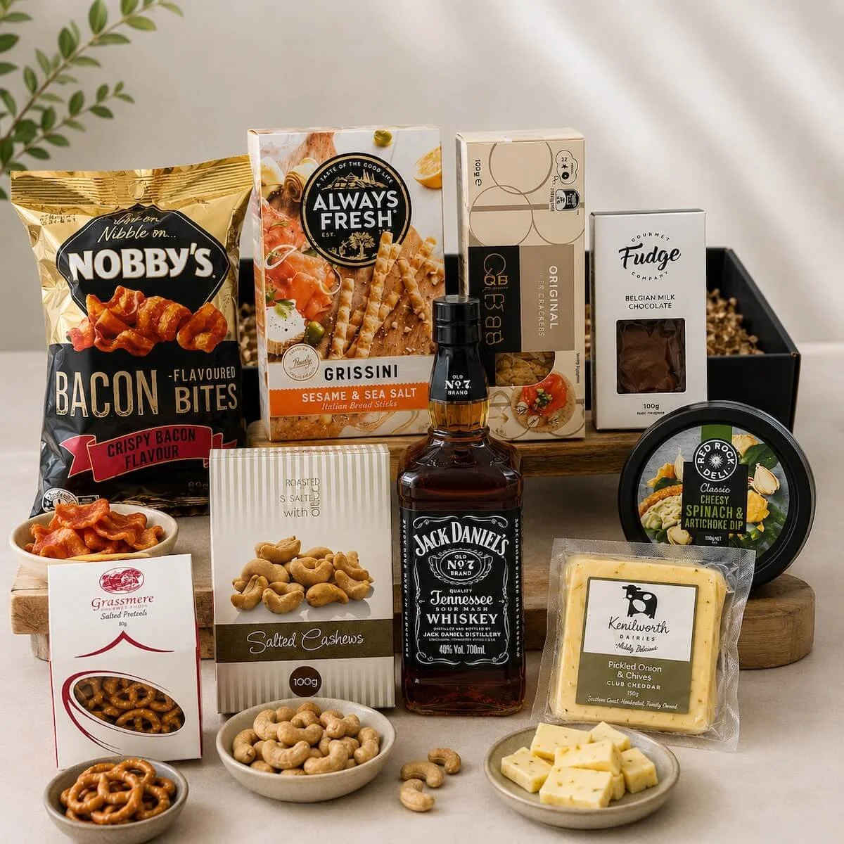 Gourmet Alcohol hamper items a bottle of spirits, cheese, dip, cashews, crackers, fudge, pretzels, Grissini and pork crackle.