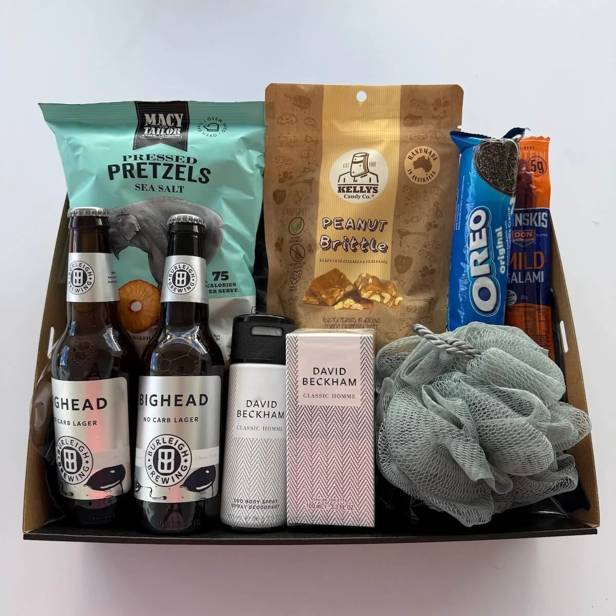 Gentlemans gift hamper with beer, pretzels, brittle, oreos, washer and david beckhamp pamper items.