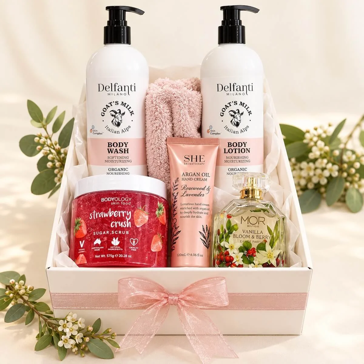 Luxury pamper gift hamper in a white gift box with Delfanti goat’s milk body wash and lotion, strawberry body scrub, hand cream, perfume and pink towel, beautifully presented with a pink ribbon. Avail