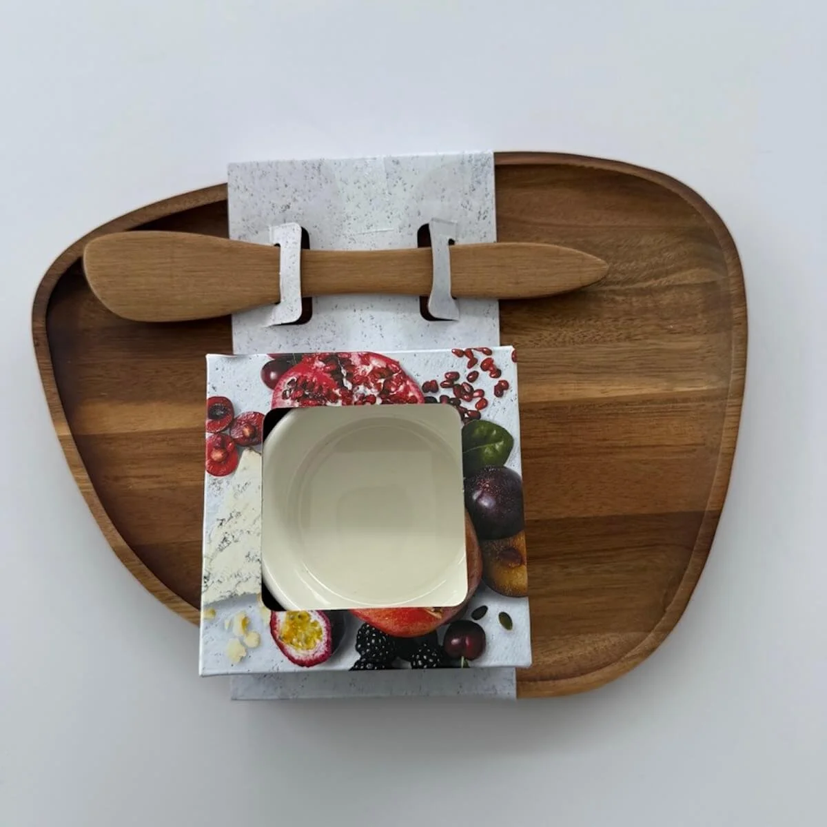 Wooden Scraper and board and serving bowl gift sitting on a brown background.