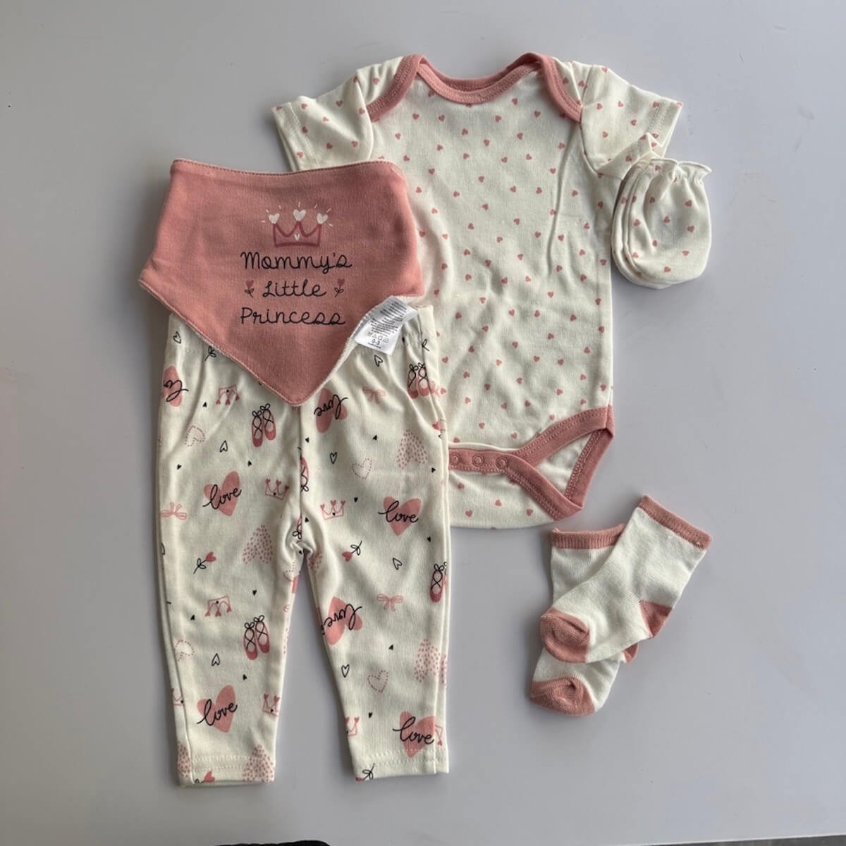 Clothing set included in baby basket, pants, body suit, socks, mittens, hat and bib.