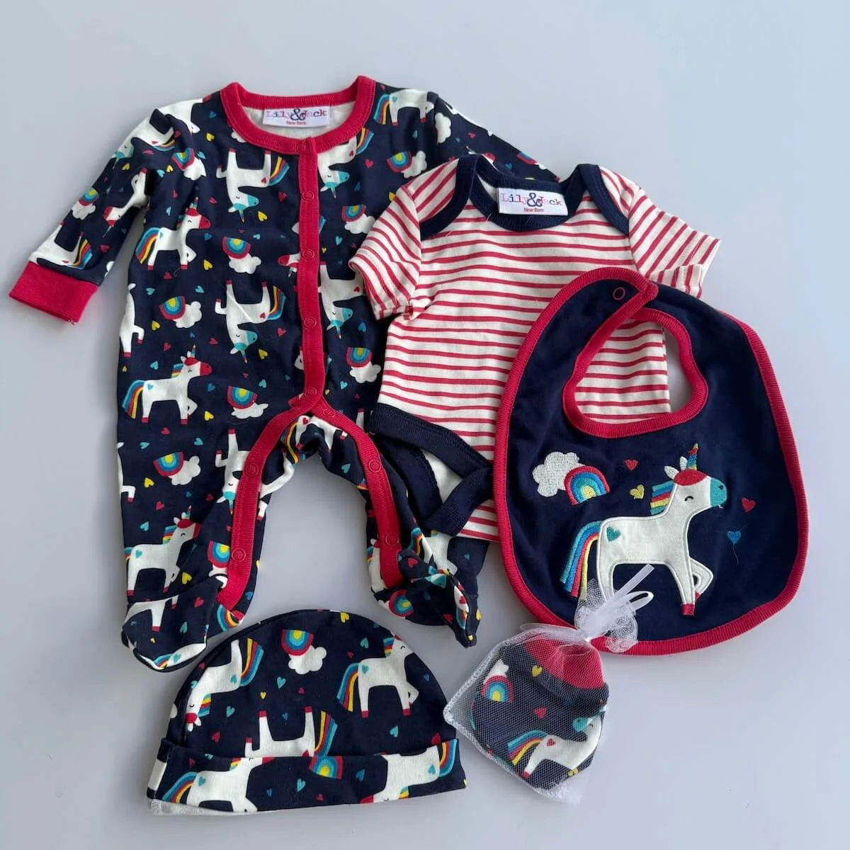 Newborn size 5-piece clothing set for a baby. Included in the set is a bodysuit, legless bodysuit, Bib, Hat and Mitten.