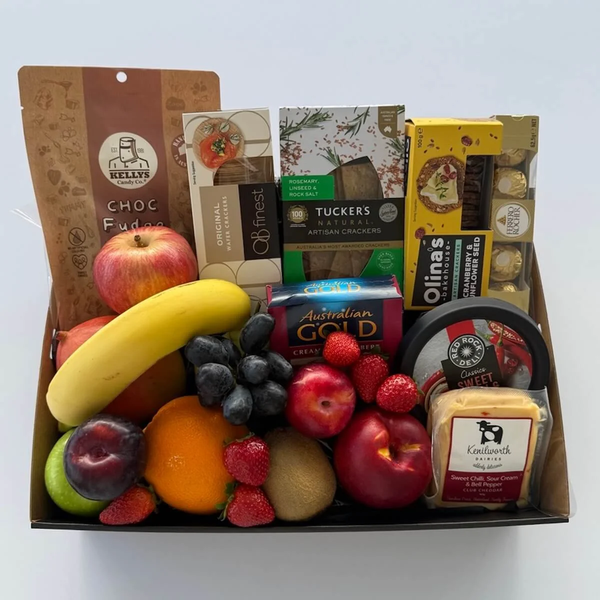 Robina Fruit Hamper gift tray featuring fresh seasonal fruit, gourmet cheeses, crackers, fudge, Ferrero Rocher chocolates, and savoury dip, beautifully wrapped with cellophane, ribbon, and bow for gifting