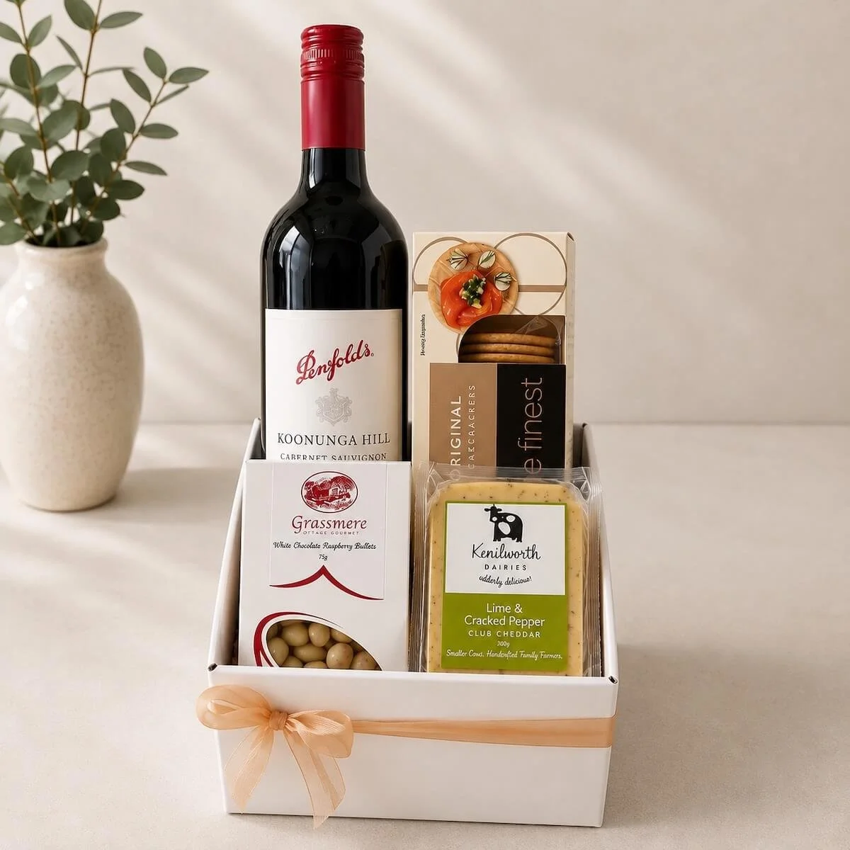 Penfolds red wine gift hamper with gourmet crackers, Kenilworth cheddar and Grassmere chocolate treats, beautifully presented in a white gift box.