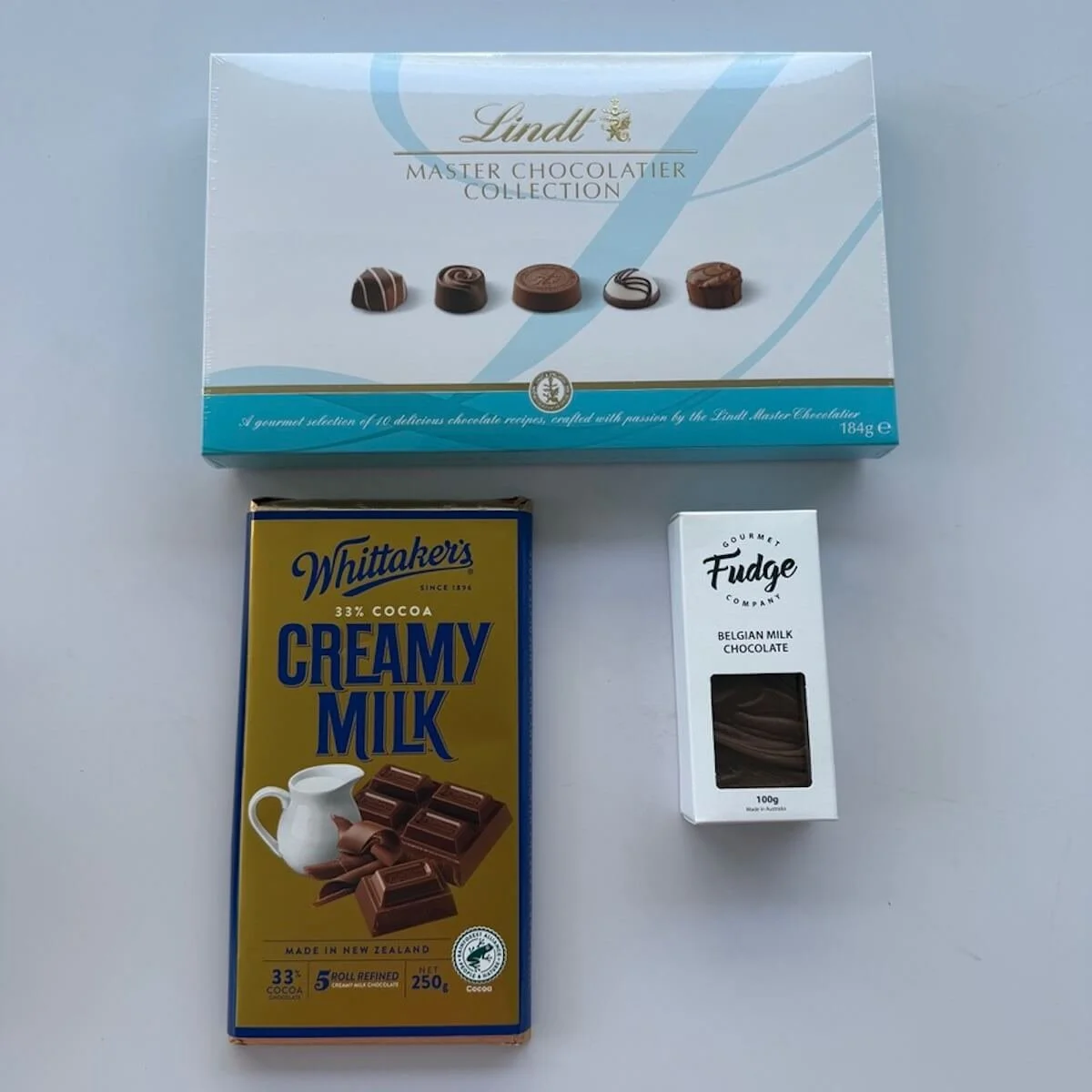 Chocolate tower chocolates. Lindt collection 184g, whittakers milk chocolate bblock 200g, and gourmet fudge 100g.