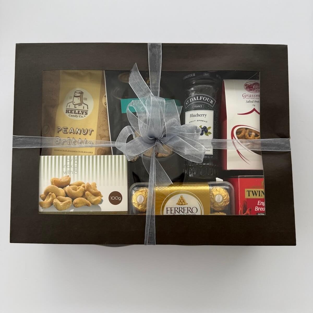 Ferrero Rocher gourmet gift box with lid on, tied with elegant ribbons in a black window gift box