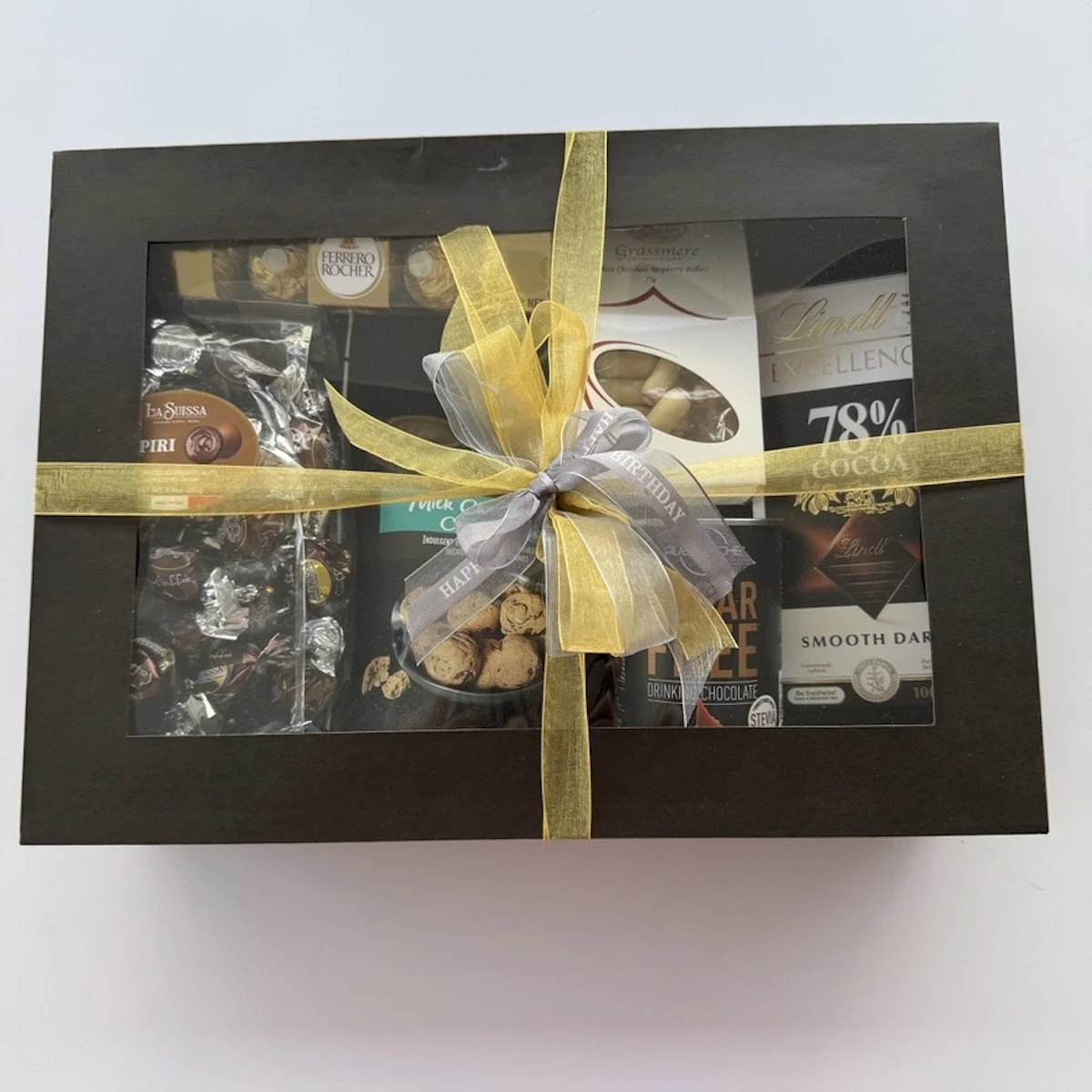 Premium chocolate gift box filled with Lindt, Ferrero Rocher, pralines, cookies and sugar-free drinking chocolate, finished with ribbons and bows.