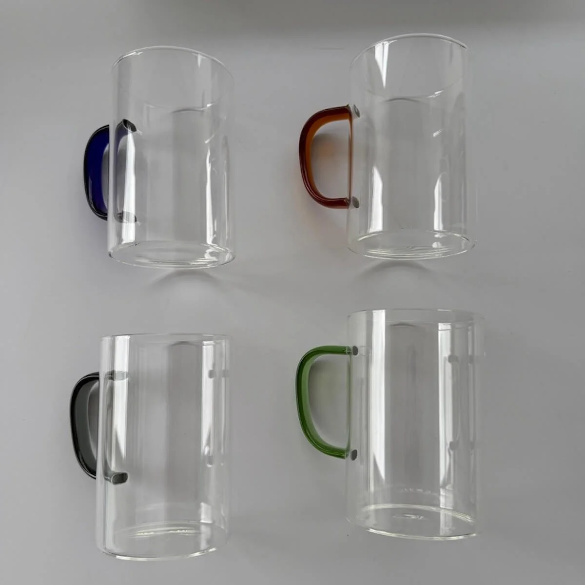 4 glass coffee cups each with a different colour handles in a gift hamper for a house warming gift.