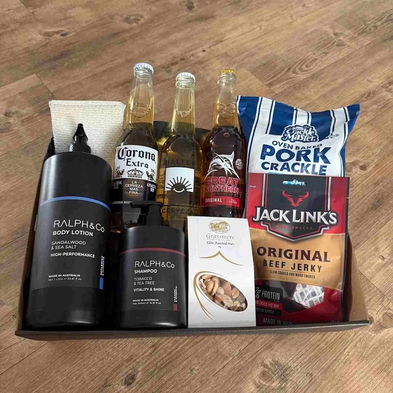 Men's beer and snck hamper with craft beers, pork crackle, beef jerky, nuts, and Ralph & Co grooming products.