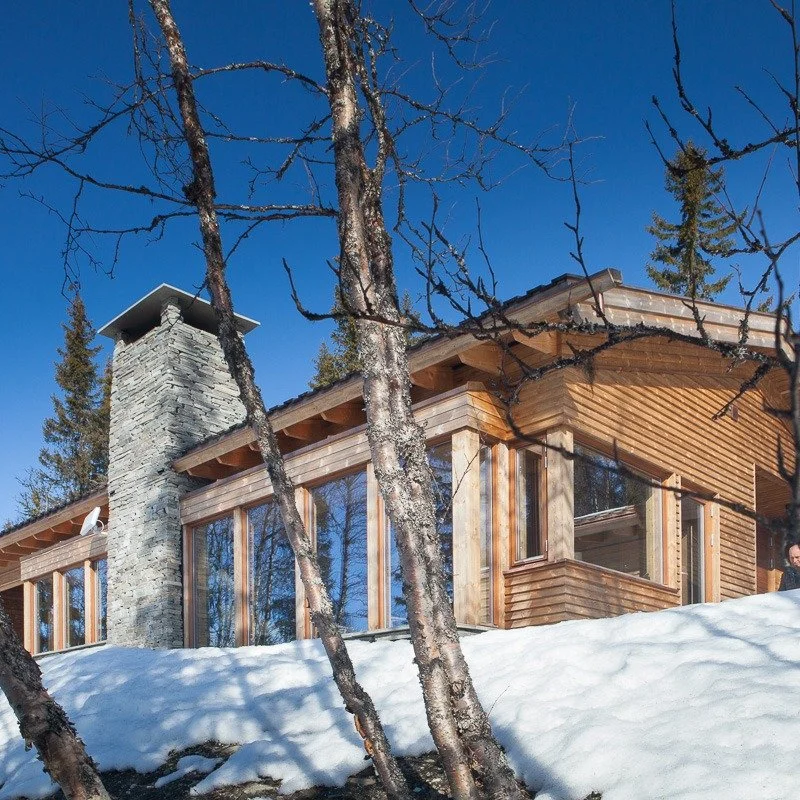 Plassert på en usjenert, sørvendt tomt med urørt natur rundt – der utsikt og terreng har fått styre utformingen.
Hytta er trappet i terrenget: soverom og våtrom på øvre nivå, og luftige opphol