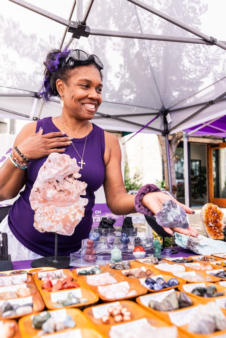 A woman buying an Amethyst rock from a vendor.