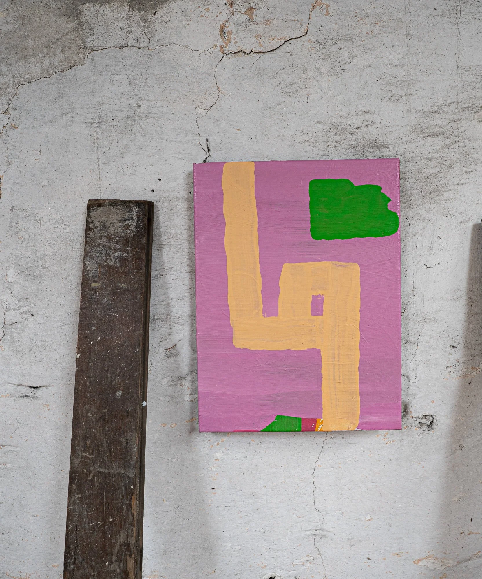Small abstract oil painting on stone studio wall, lavender pink ground with ochre angular form and green shapes, West Cork studio, Martin Finnin Irish artist