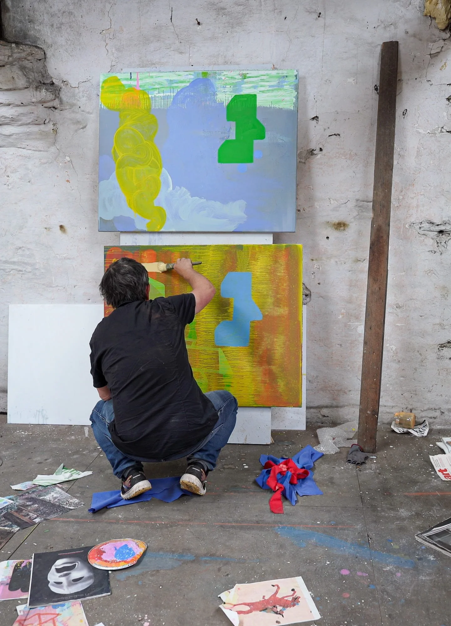 Irish artist Martin Finnin working on canvas on studio floor with Landscape With Turf and Mint Ice Cream Sky visible above, two abstract paintings in progress in West Cork studio