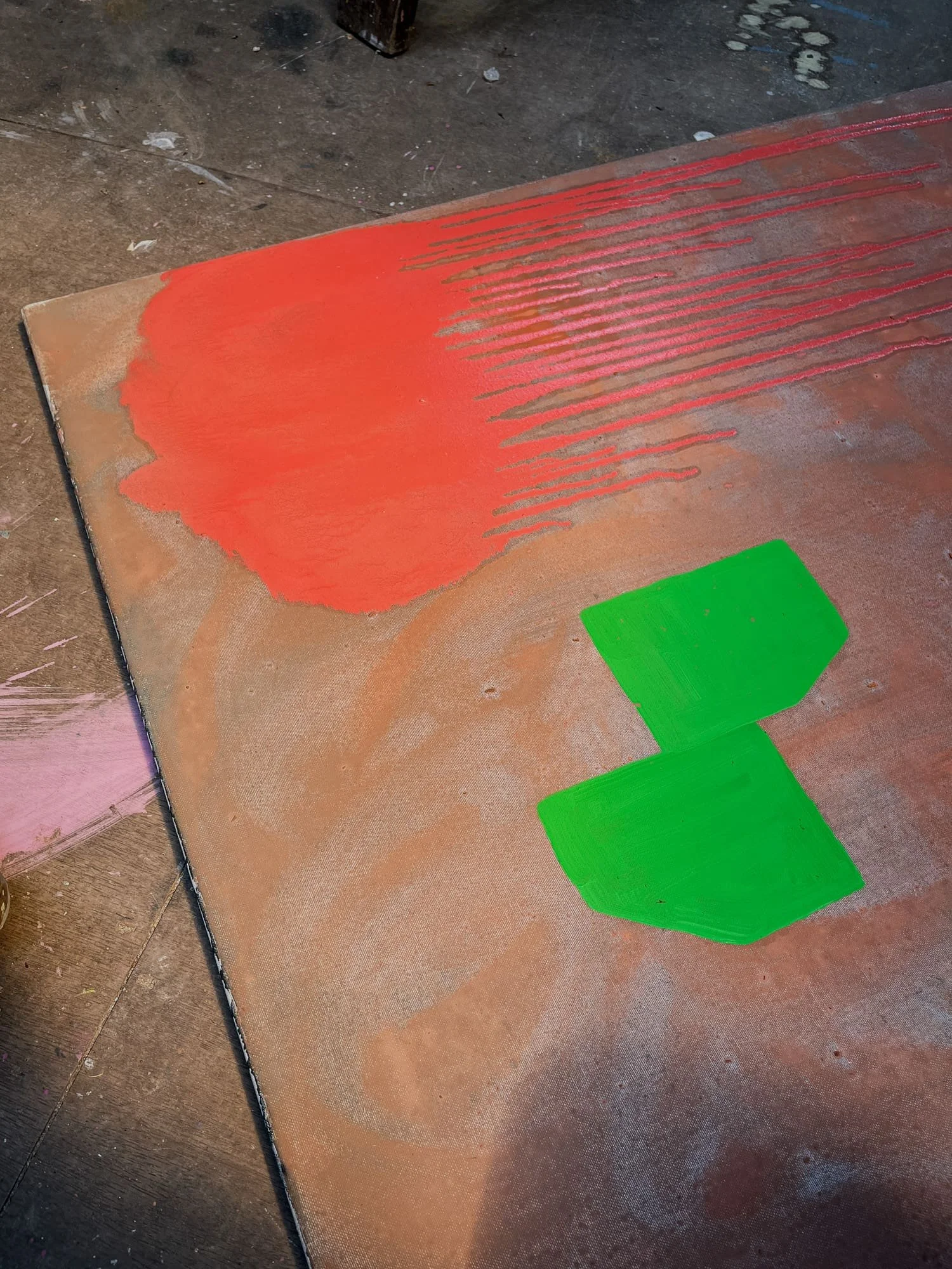 Early stage canvas on studio floor, vivid orange red and bright green forms on terracotta ground, abstract oil painting in progress, Martin Finnin West Cork studio