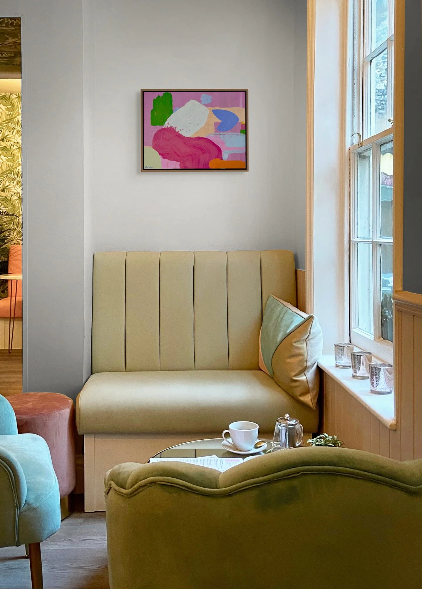 Colourful abstract oil painting above velvet seating in warm eclectic interior, pink green blue and white contemporary art in boutique hotel setting, Martin Finnin Irish artist