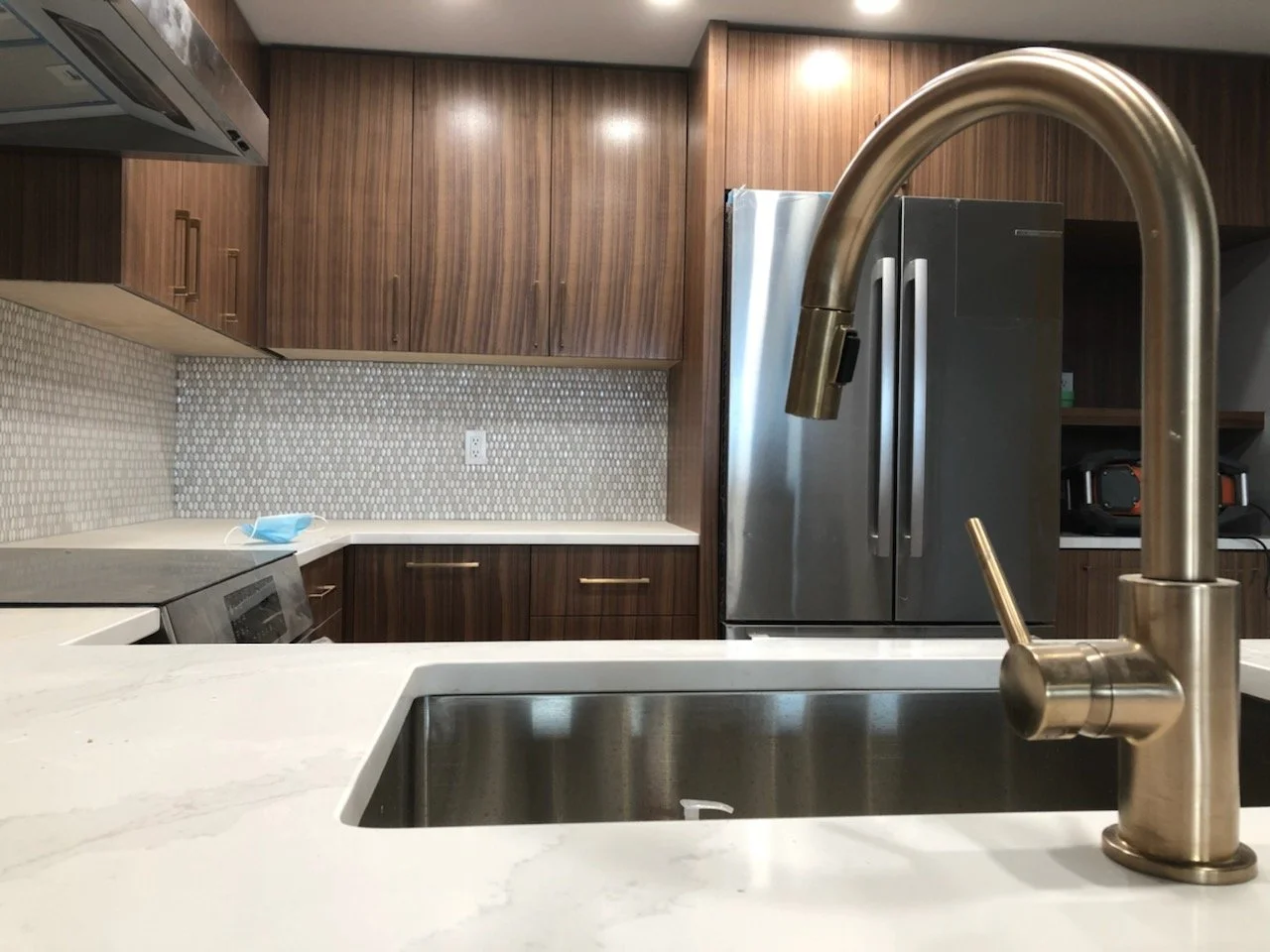 Modern kitchen renovation finished with high quality cabinetry, quart counters, and new appliances.