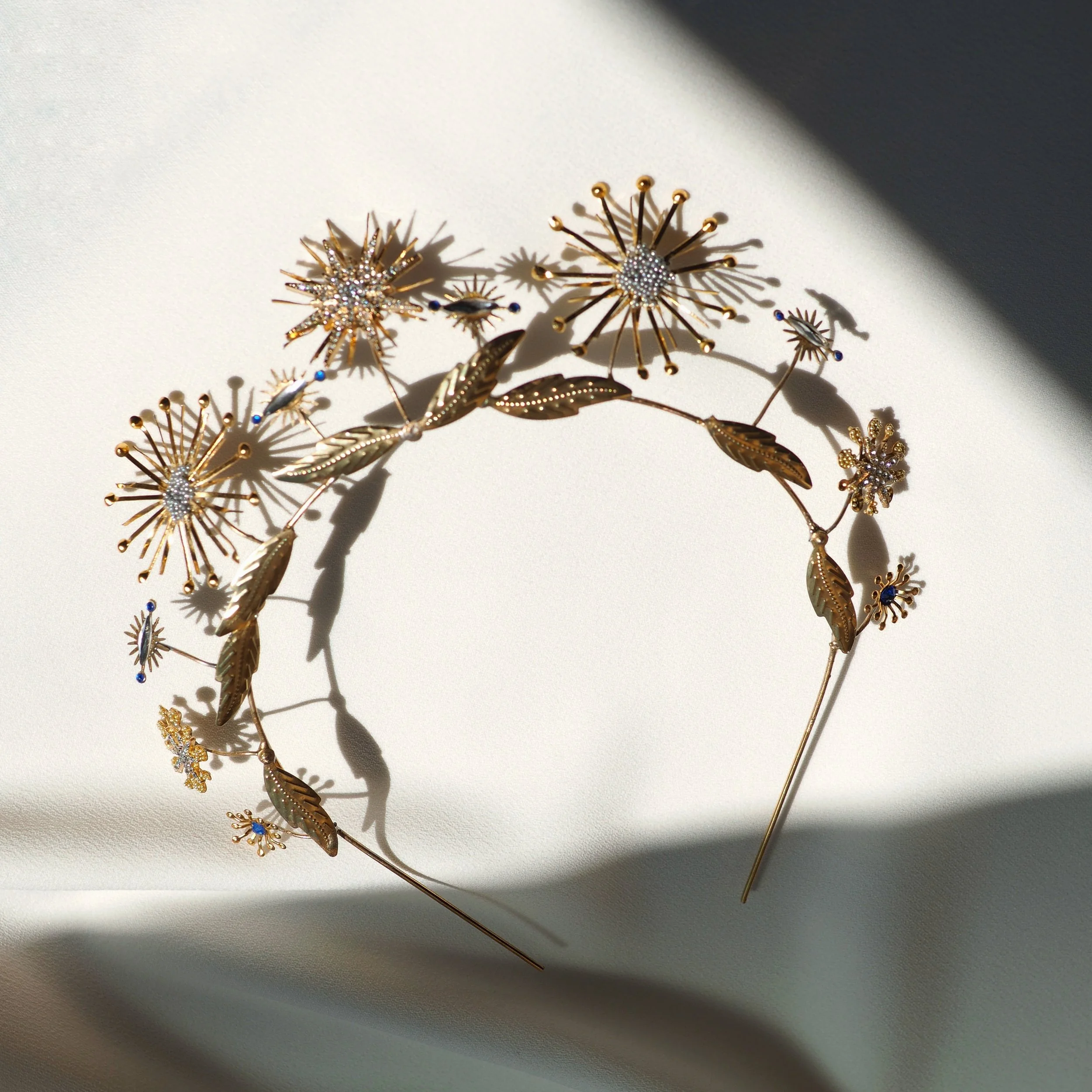 Gold floral headpiece with intricate design on white background