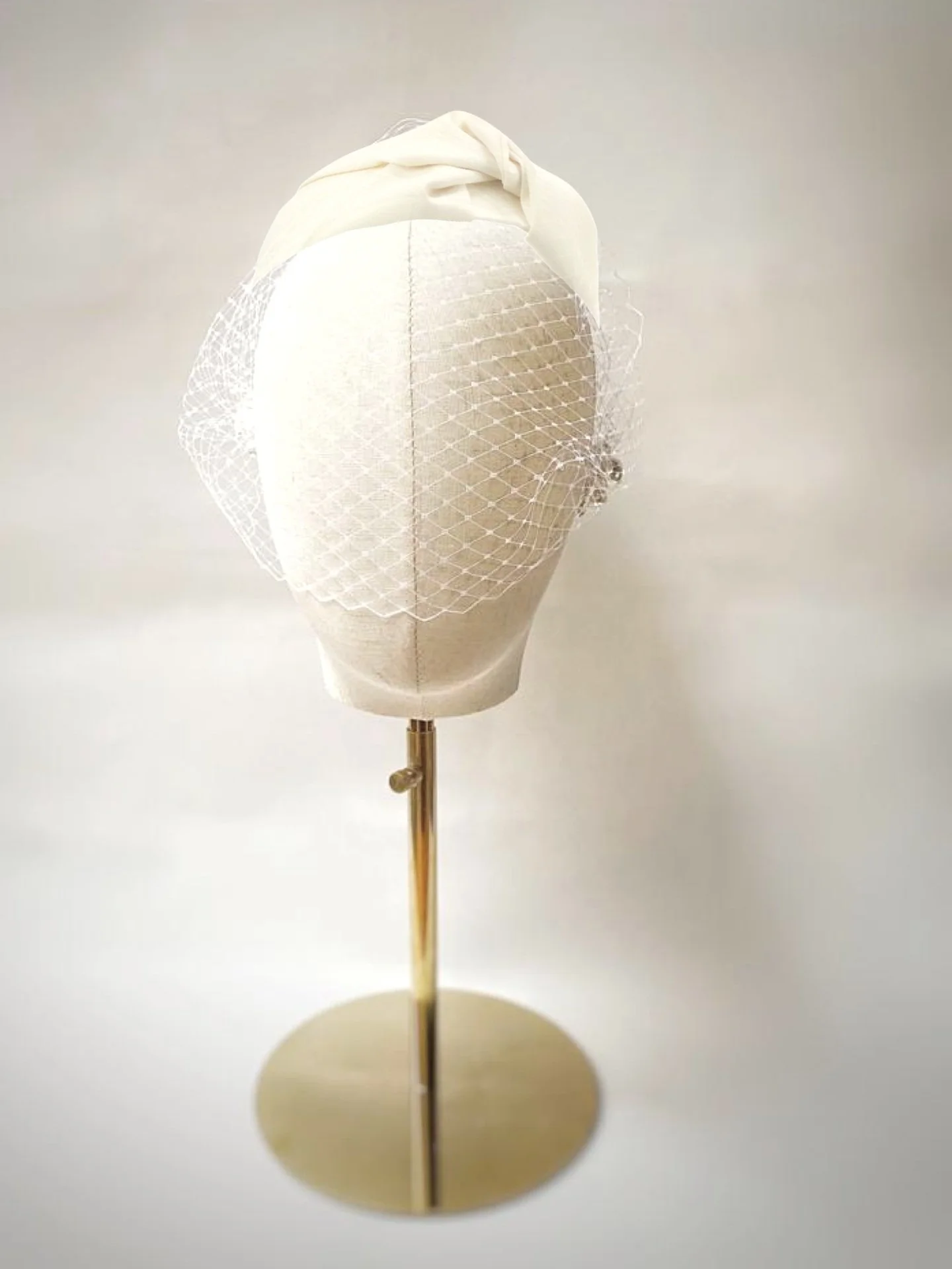 White headpiece with veil on display mannequin