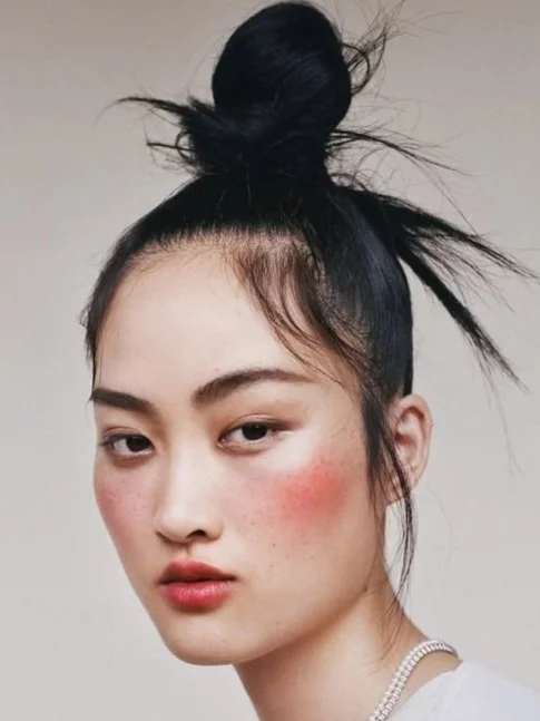 Woman with a topknot hairstyle and red blush