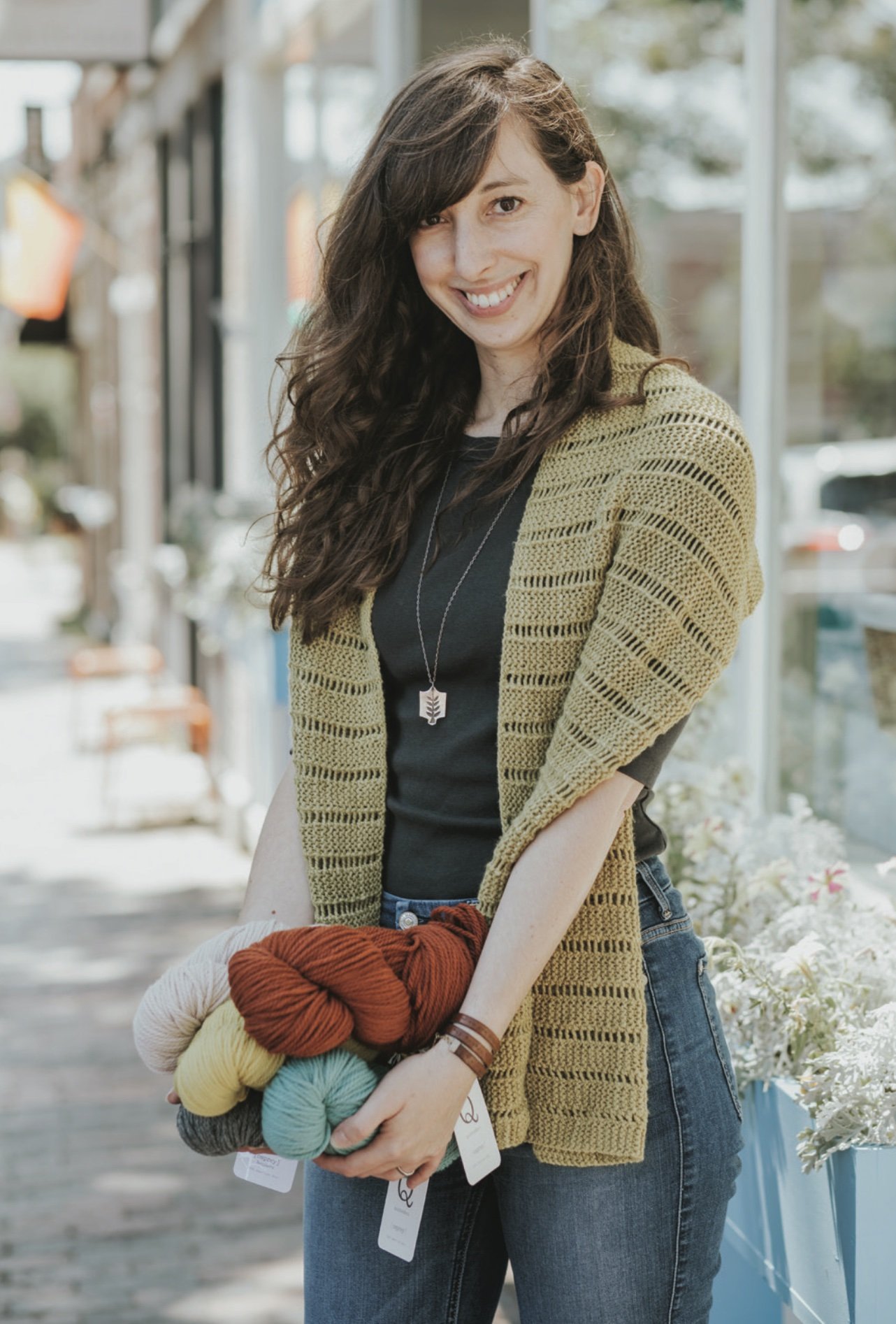 Elizabeth Smith, photographed in front of KnitWit, the Portland store where she works a few days a week and gains insights from customers. That yarn she’s holding is made by Maine company Quince & Co. Photo by Heidi Kirn