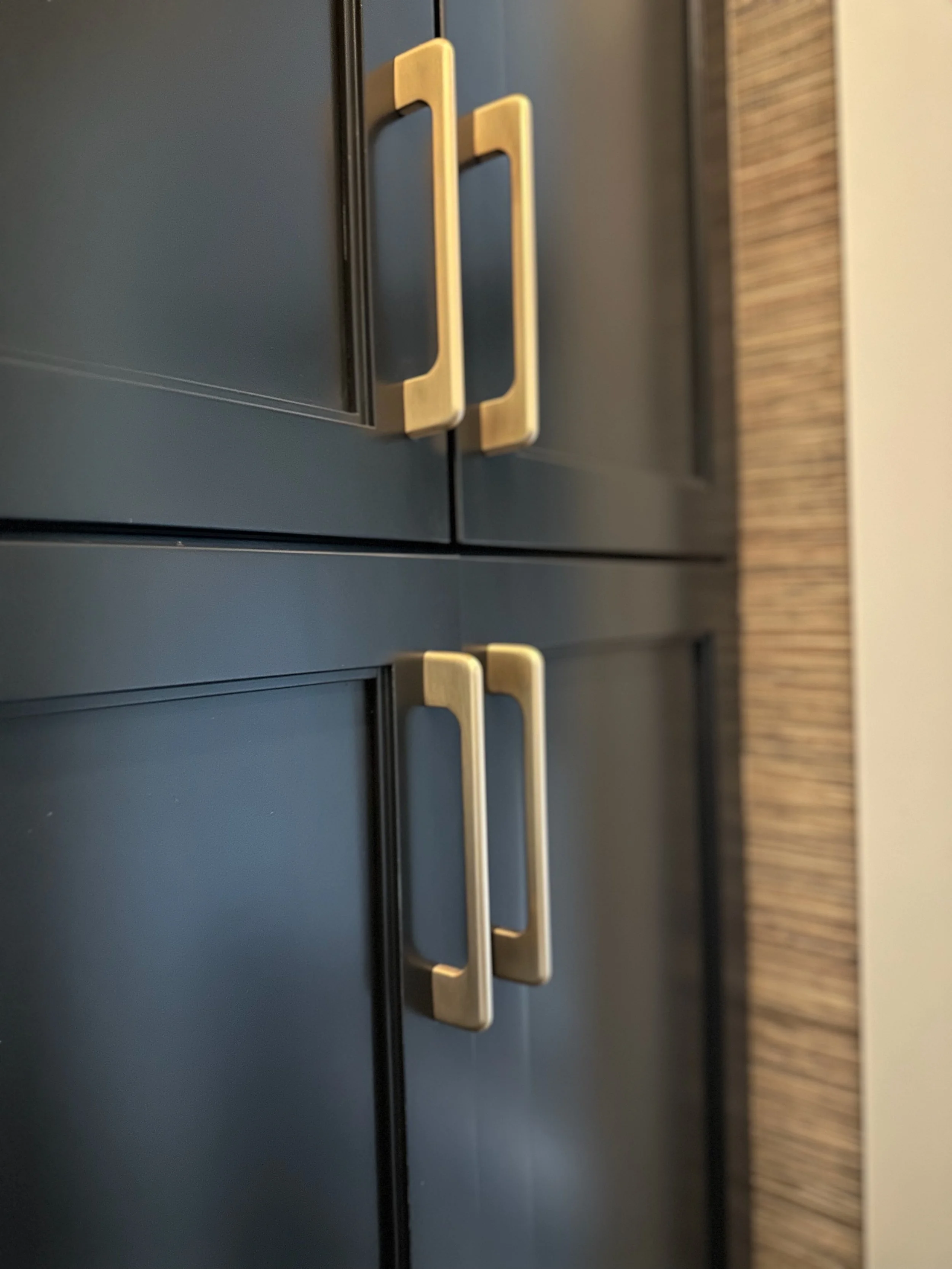 Close-up of dark cabinets with gold handles.