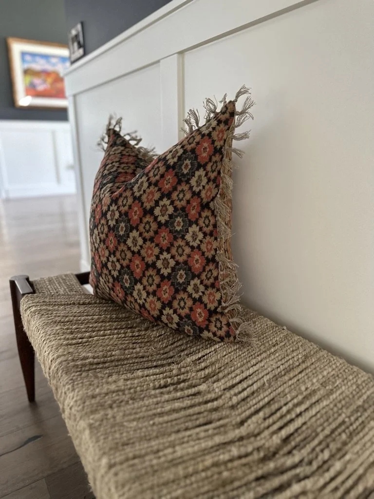 Decorative pillow with floral pattern on woven bench