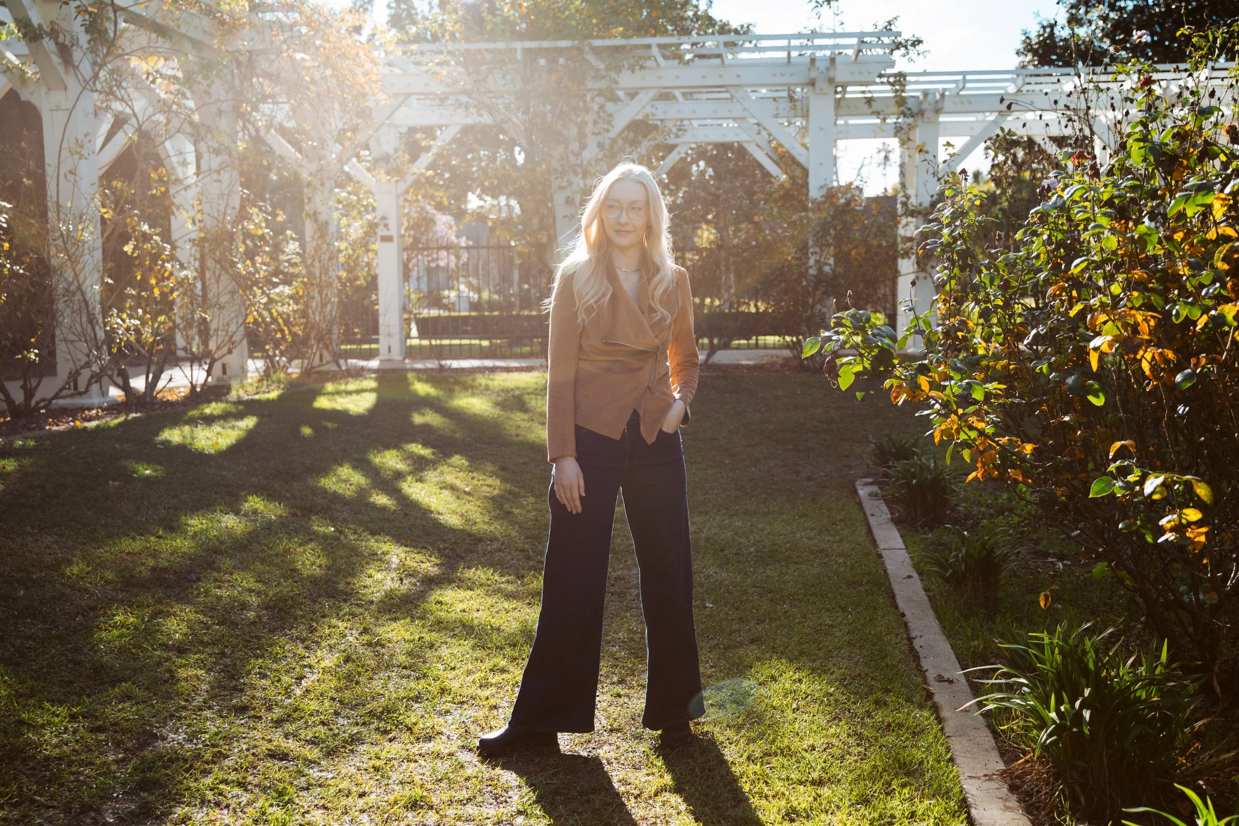 Andi Cabello LMFT in a garden standing and smiling