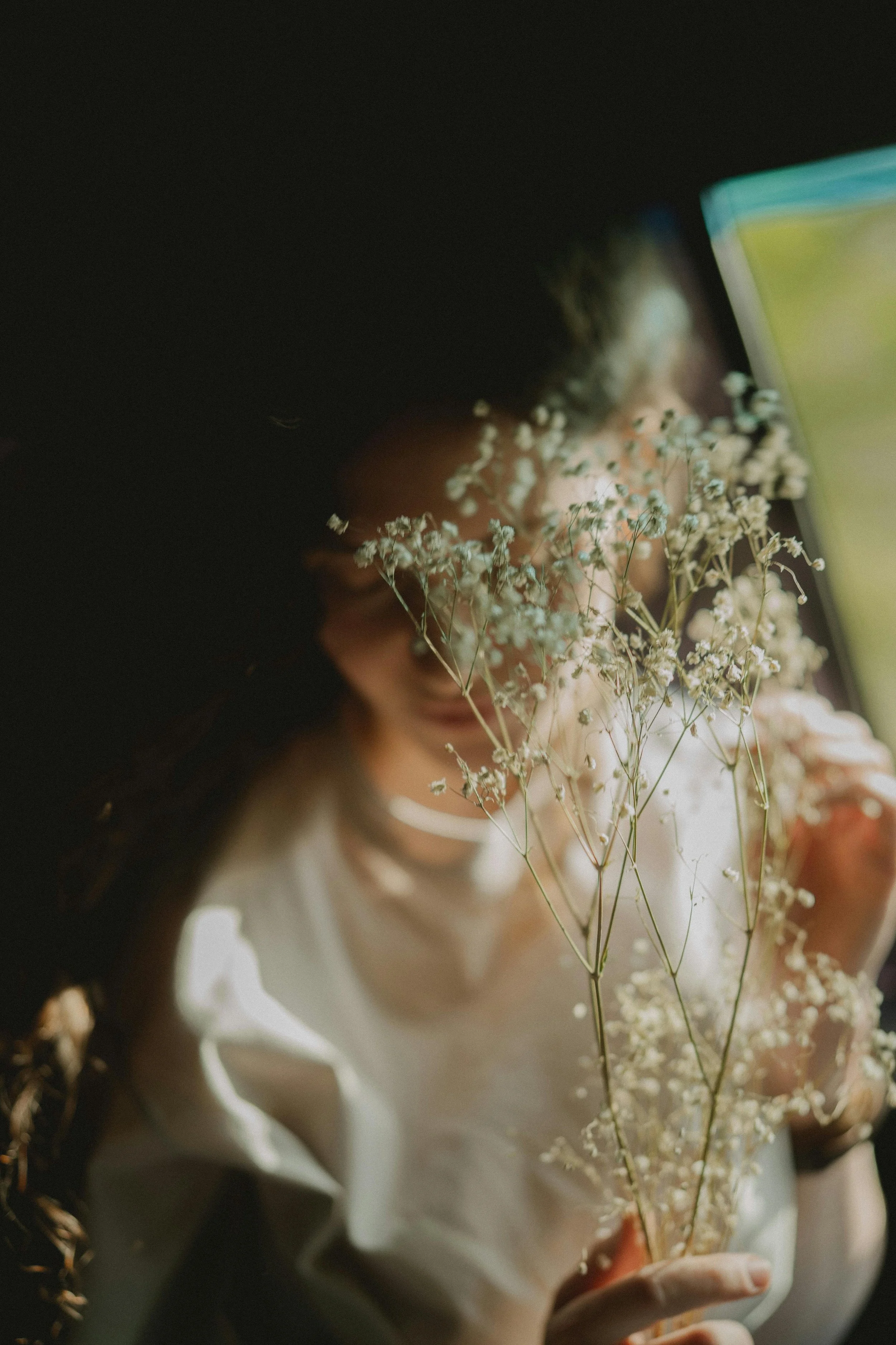 A person holding flowers in front of their face