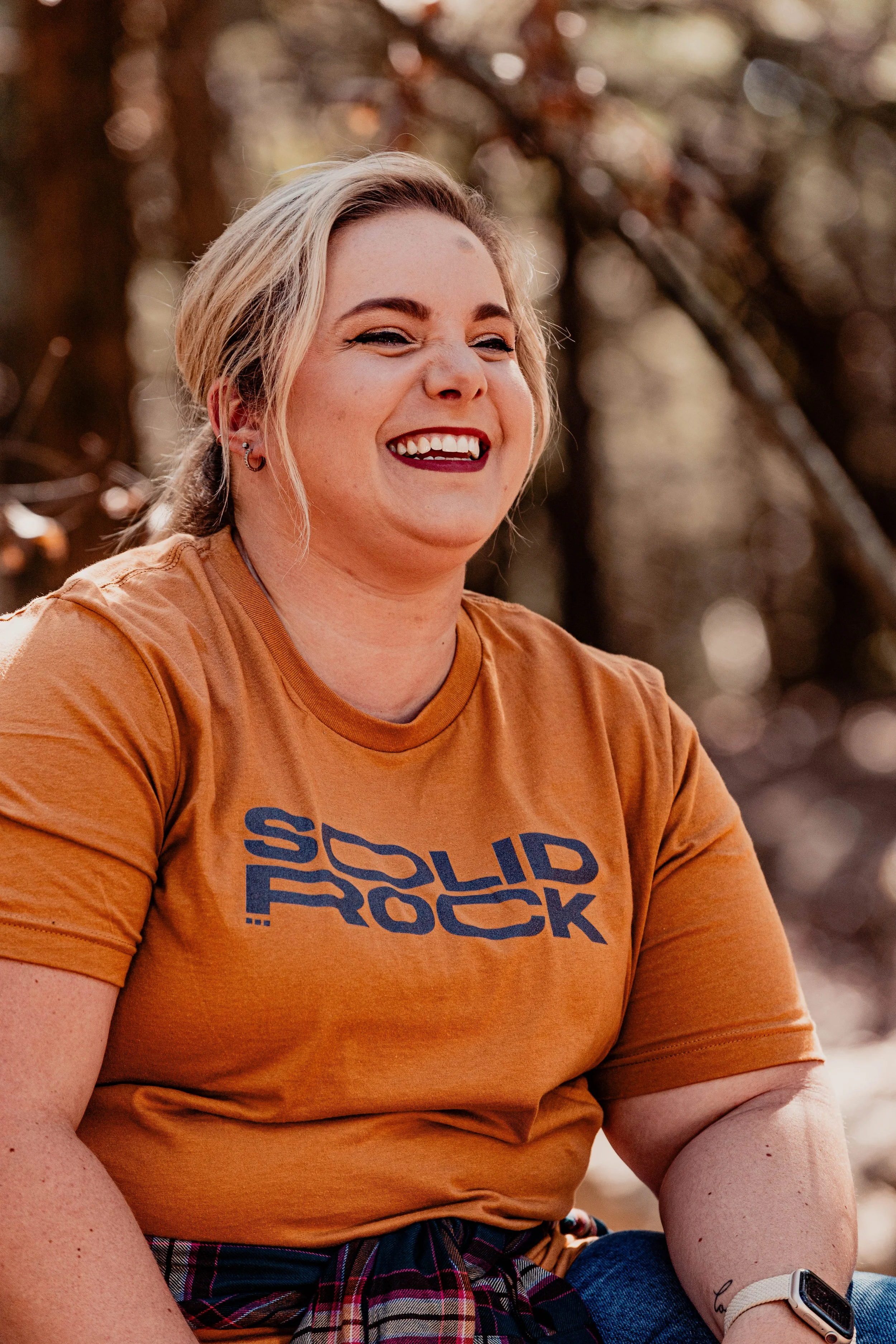 Solid Rock case study: smiling woman outdoors wearing an orange Solid Rock campaign t-shirt