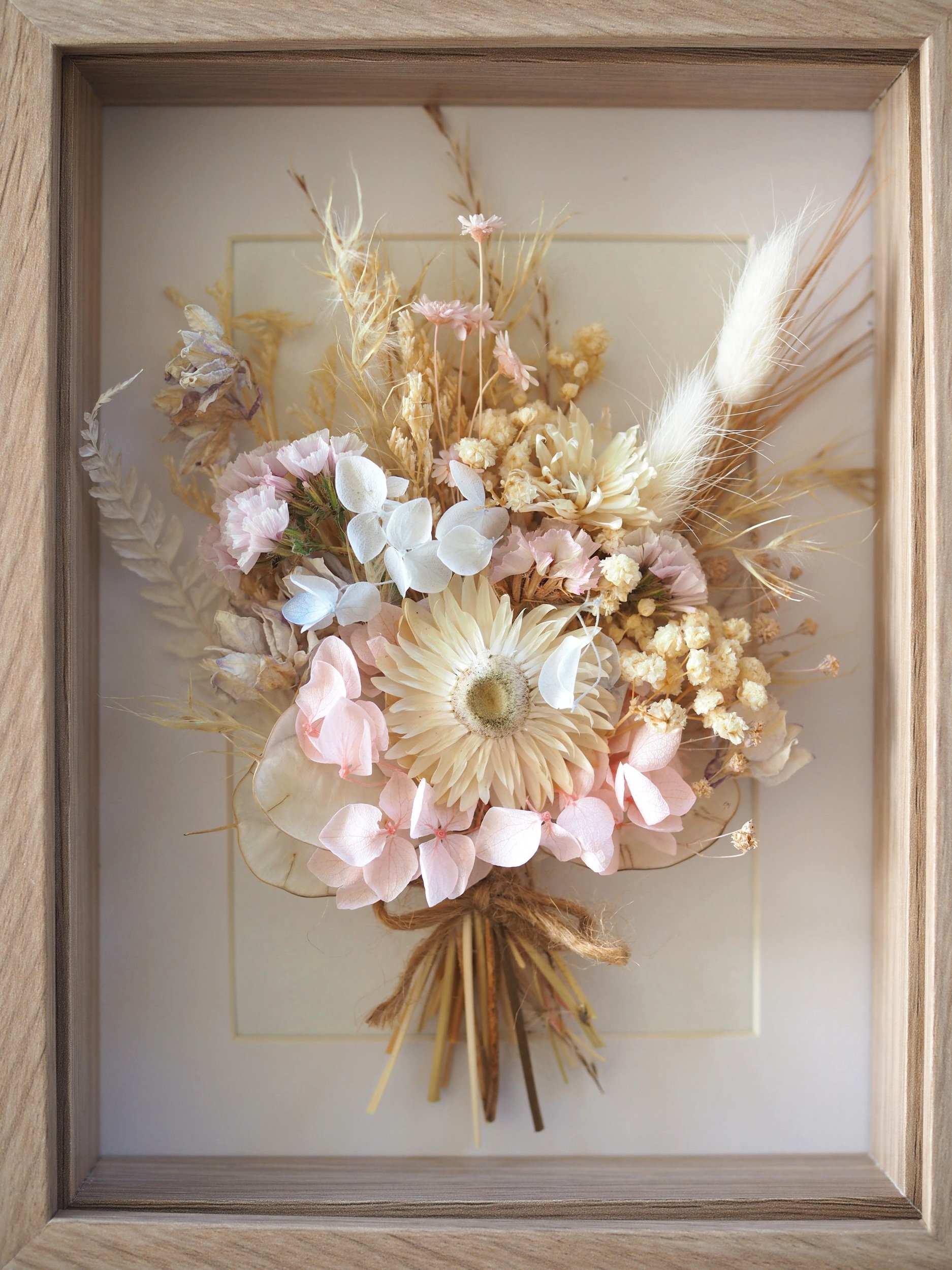 Petite Fleurs Frame – 15cm x 20cm The Petite Fleurs Frame features a dainty bouquet of dried flowers, thoughtfully arranged against a crisp white background and enclosed in a natural wood grain frame