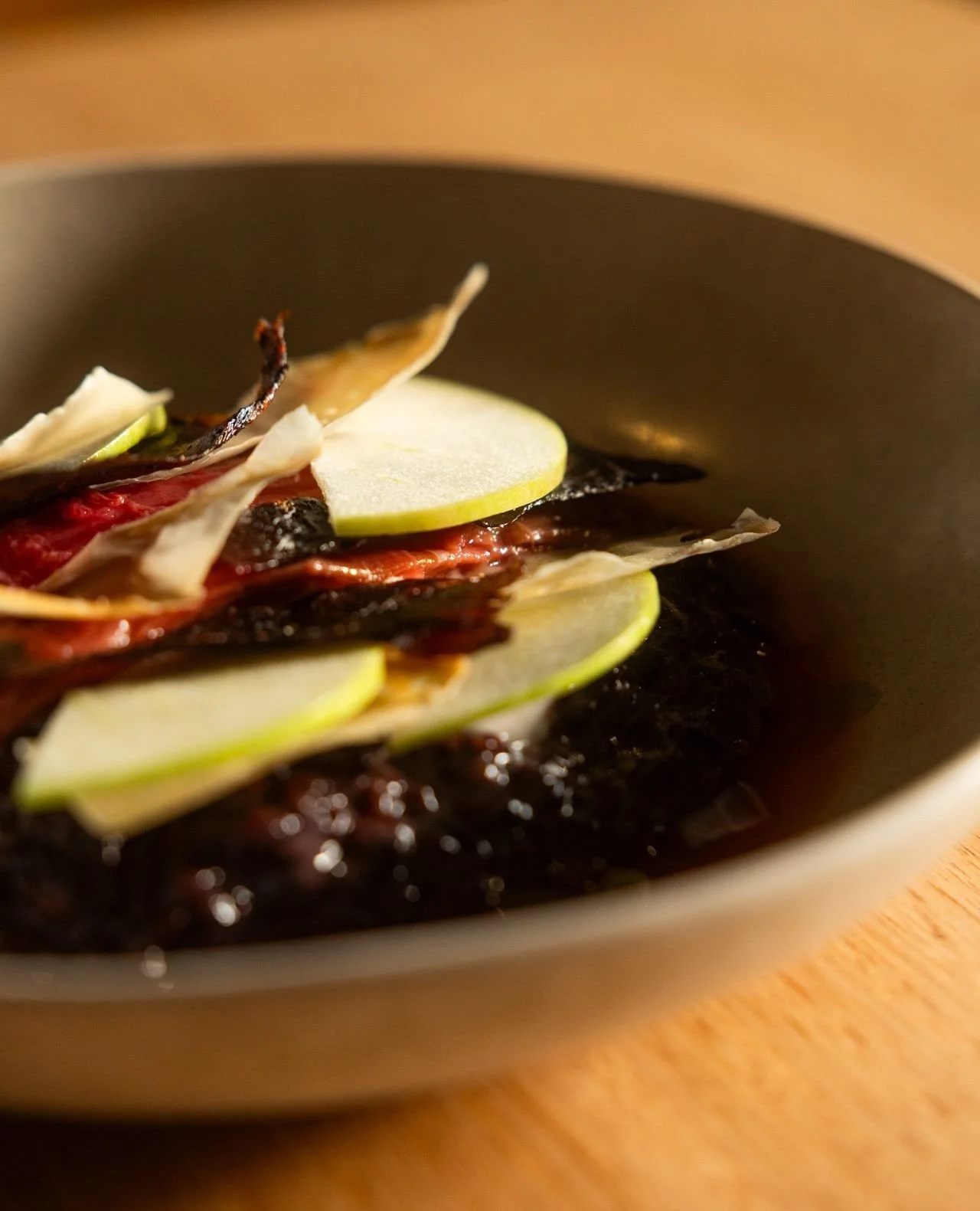 Take a bite of our black rice pudding.⁠
⁠
If the close-up of fresh apple doesn&rsquo;t win you over, maybe the coconut yoghurt, crispy coconut, strawberry gum syrup and black sticky rice underneath will.⁠
⁠
Sweet, comforting, and worth digging into