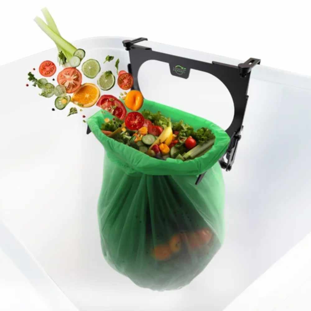 Fresh vegetable scraps falling directly into a compostable bag secured by the Hoop 2.0, showing the mess-free waste diversion process.