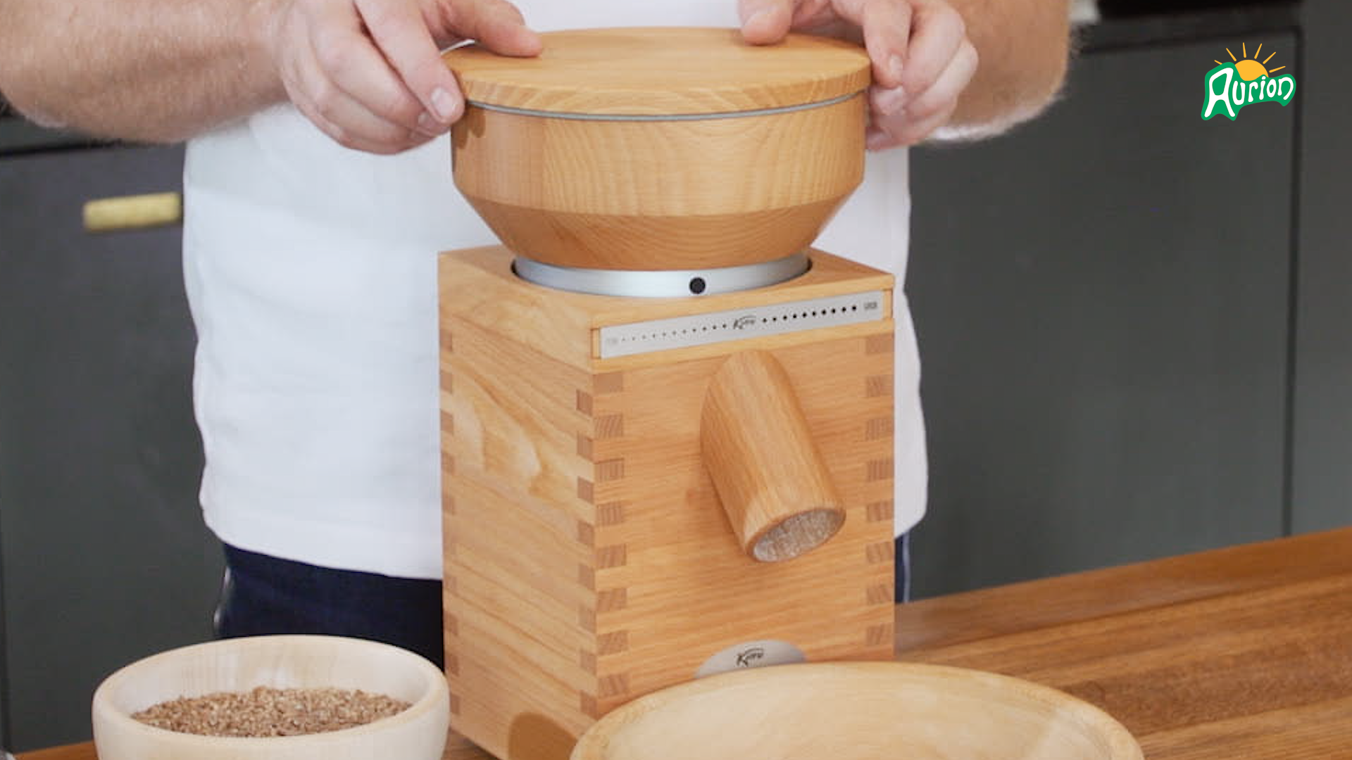 Solnedgang over en frossen sø med store klipper og trætoppede øer, omgivet af sneklædte bjerge og en mørk skov.