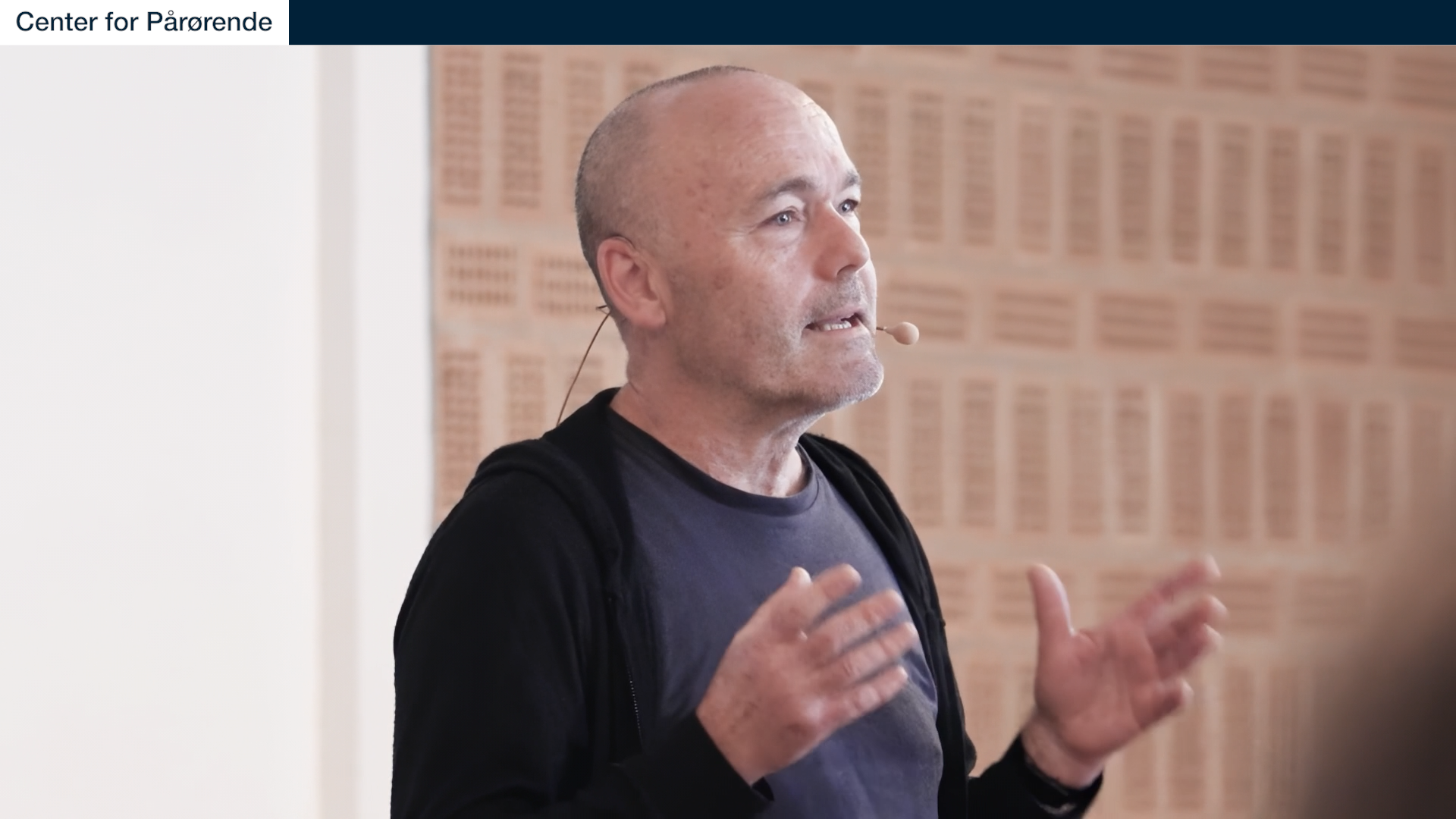 En frostklar vinterscene med en enkelt sneklædt træ i midten, omgivet af snefyldte skove under en klar, lys himmel.