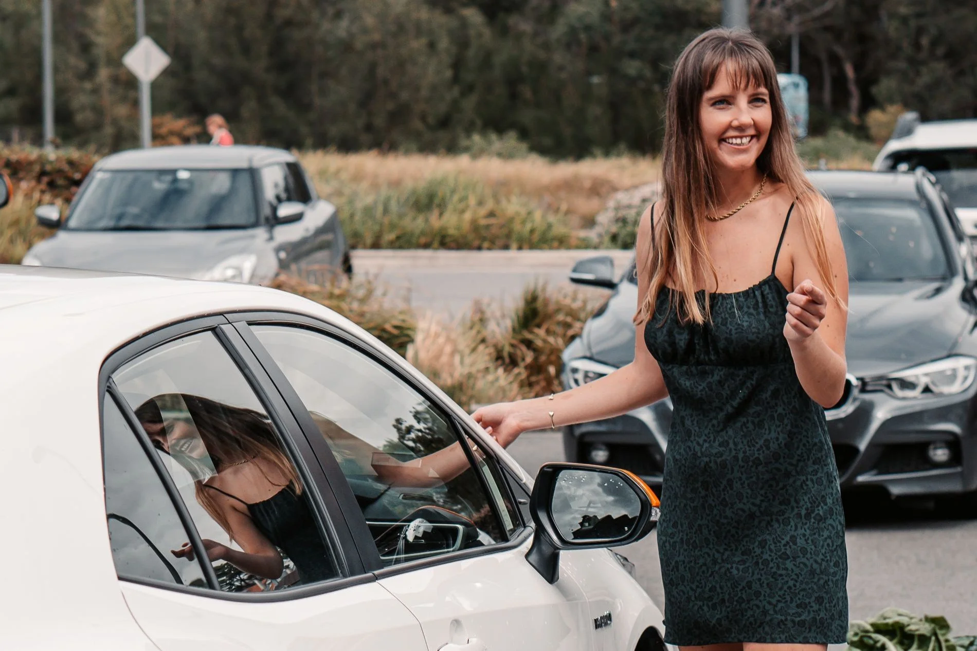 Woman unlocking a carshare vehicle on a local street using keyless access before driving away