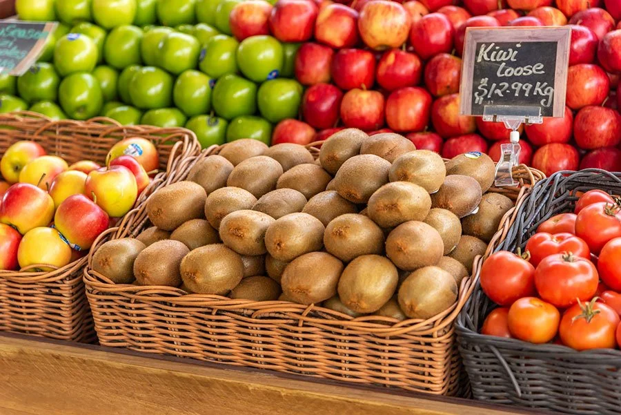 Fresh kiwi fruit and seasonal produce displayed at farmers market stand