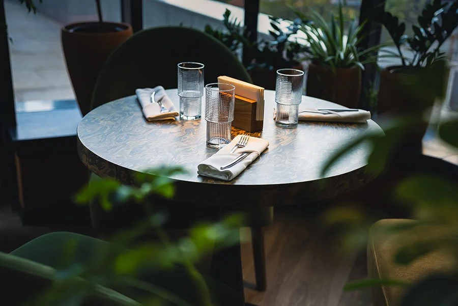 Modern café table setting with warm lighting, capturing the relaxed coffee-break vibe that pairs perfectly with a Sydney plant nursery crawl.