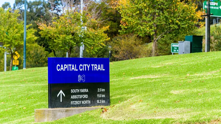 Sign for the Capital City Trail bike route near the Yarra River in Melbourne, guiding cyclists and pedestrians along the city’s loop path
