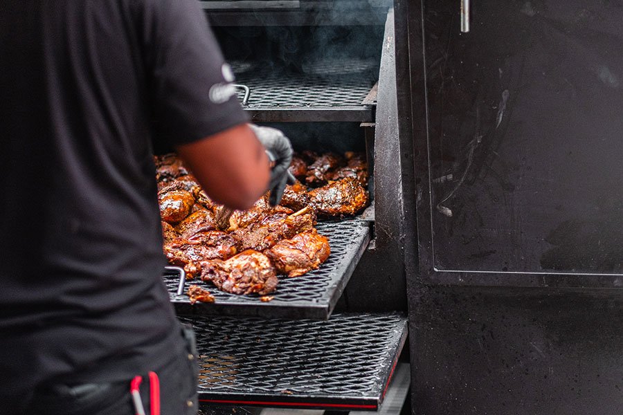 Man grilling smoky barbecue chicken outdoors, capturing the flavour and fun of a Father’s Day BBQ masterclass in Melbourne
