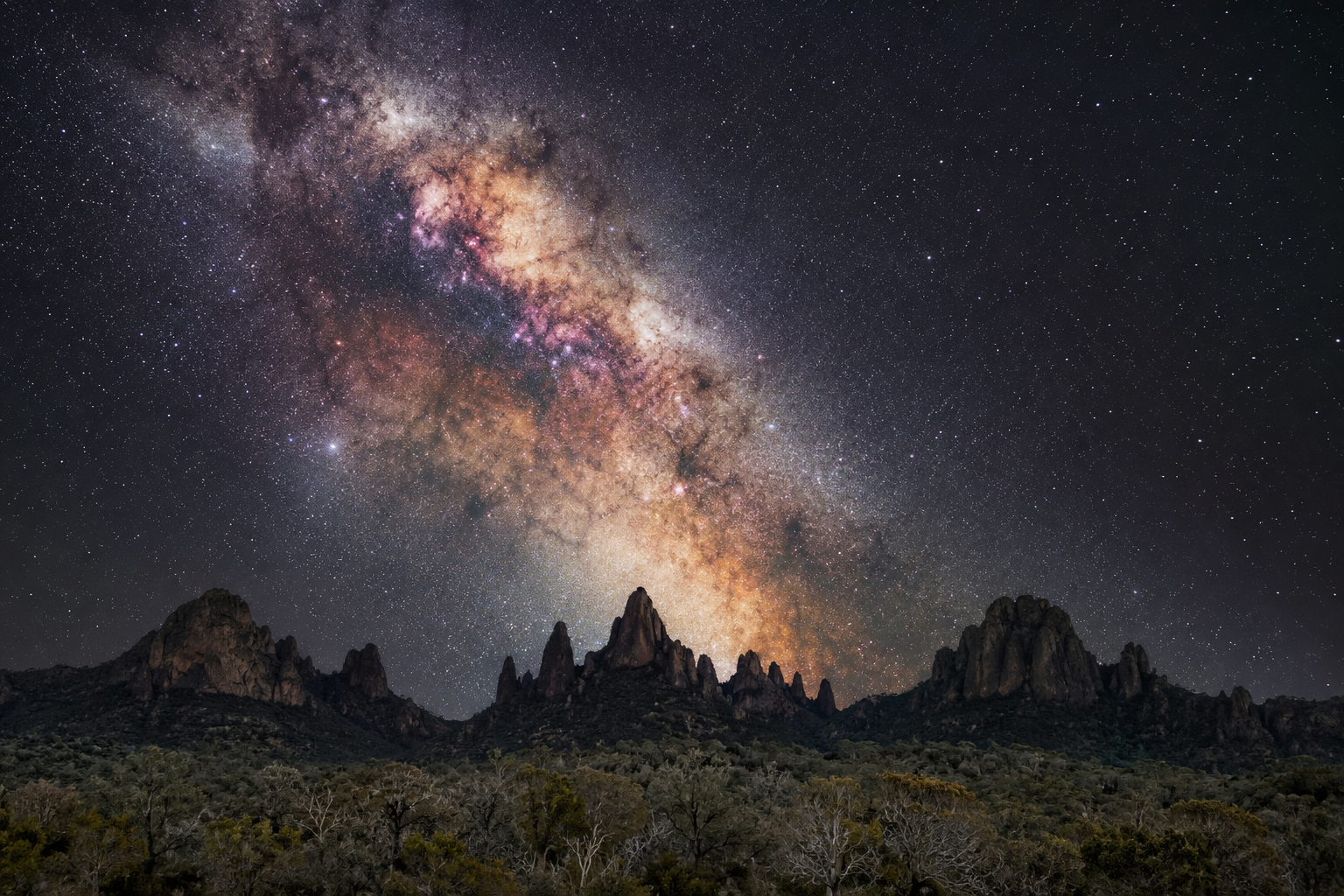 Jagged volcanic mountain peaks silhouetted against a brilliant Milky Way at Warrumbungle National Park