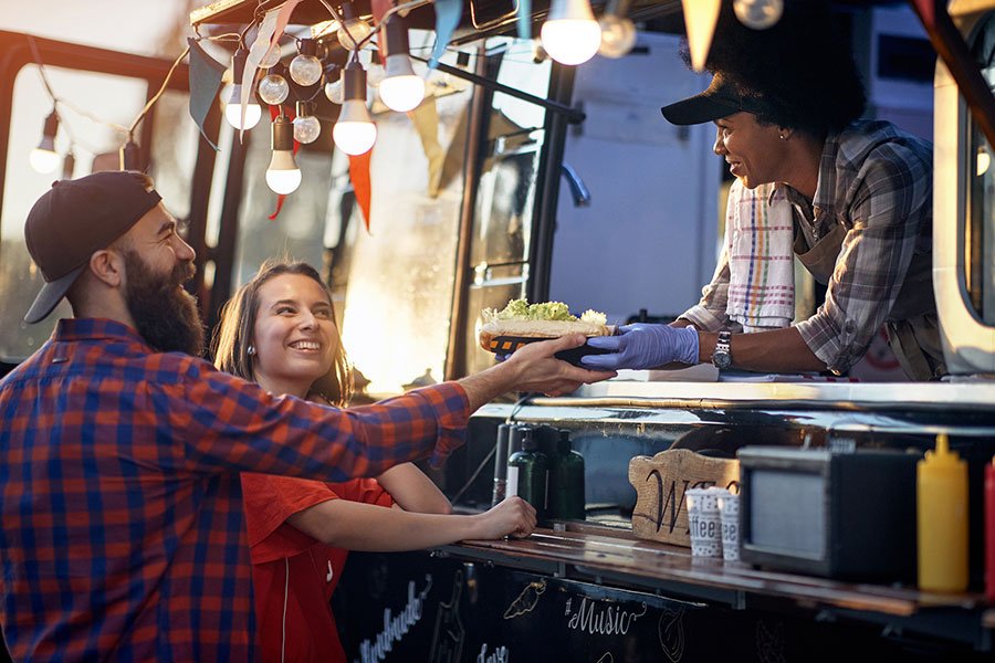 Couple ordering food from a food truck vendor at an outdoor market in Melbourne