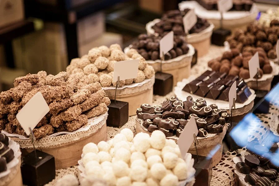 Display of handcrafted chocolate truffles and pralines in various flavors arranged in rows