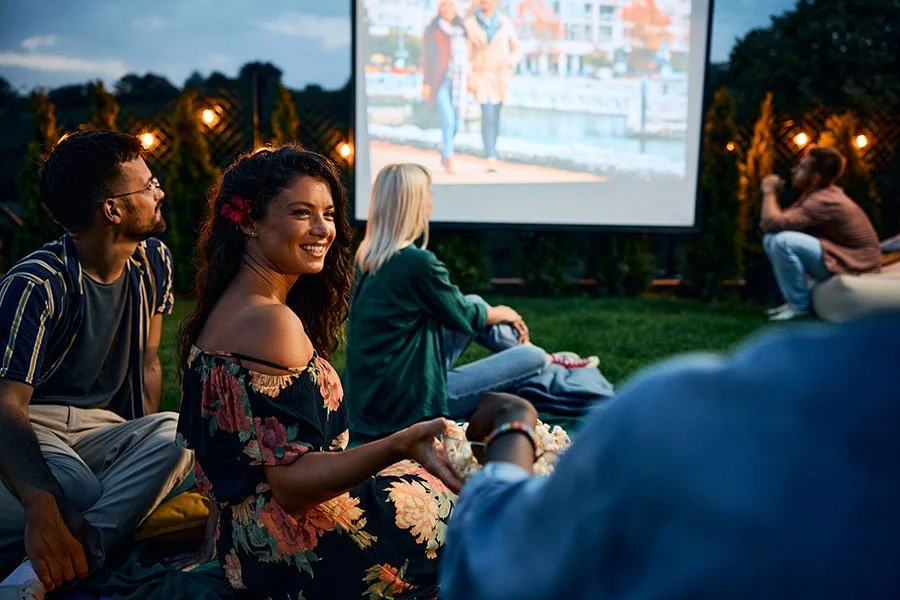 Friends enjoying an outdoor movie night with popcorn on a warm Melbourne evening