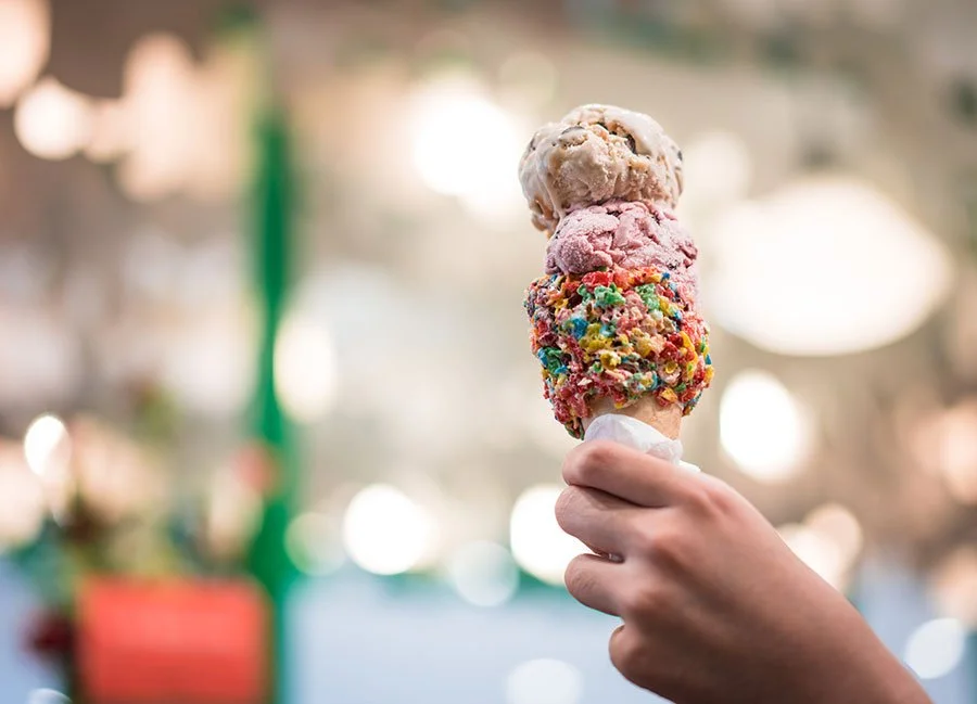 Hand holding a waffle cone with creamy ice cream — perfect for enjoying at a food truck market or dessert