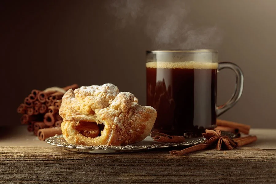 A flakey pastry and black coffee on a rustic wooden table — capturing the quiet indulgence of Melbourne’s modern suburban bakeries.
