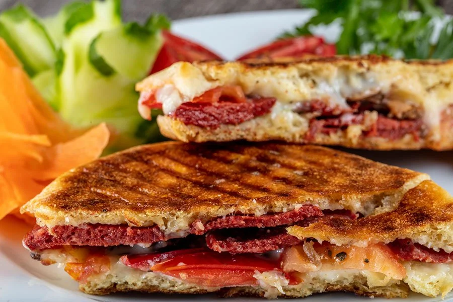 Grilled sourdough-style toast served street food–style on a rustic wooden board — ideal for showcasing international flavour fusion