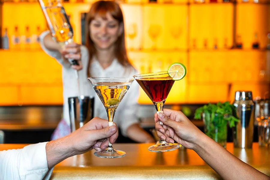 Bartender pouring cocktails into glasses, capturing the fun of a Father’s Day cocktail masterclass in Brisbane
