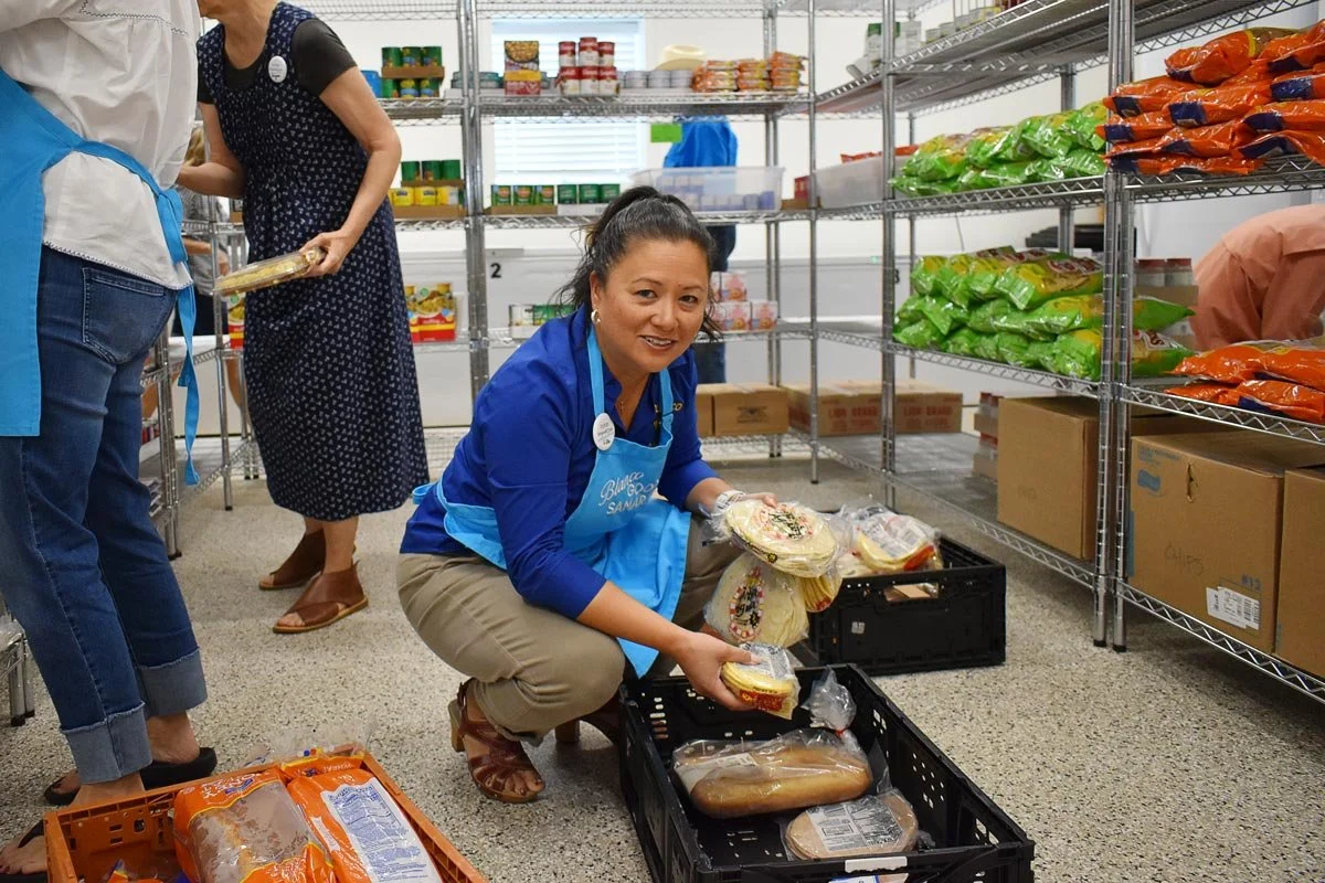 female volunteer sorting out food at the Good Samaritan thrift store and food pantry in Blanco, Texas