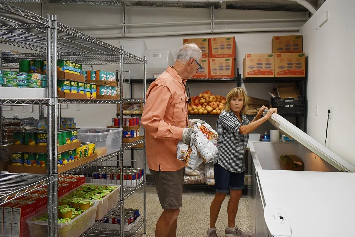 male and female volunteers getting food out of a cooler at the Good Samaritan thrift store and food pantry in Blanco, Texas