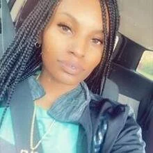 Young woman with braided hair taking a selfie inside a car.